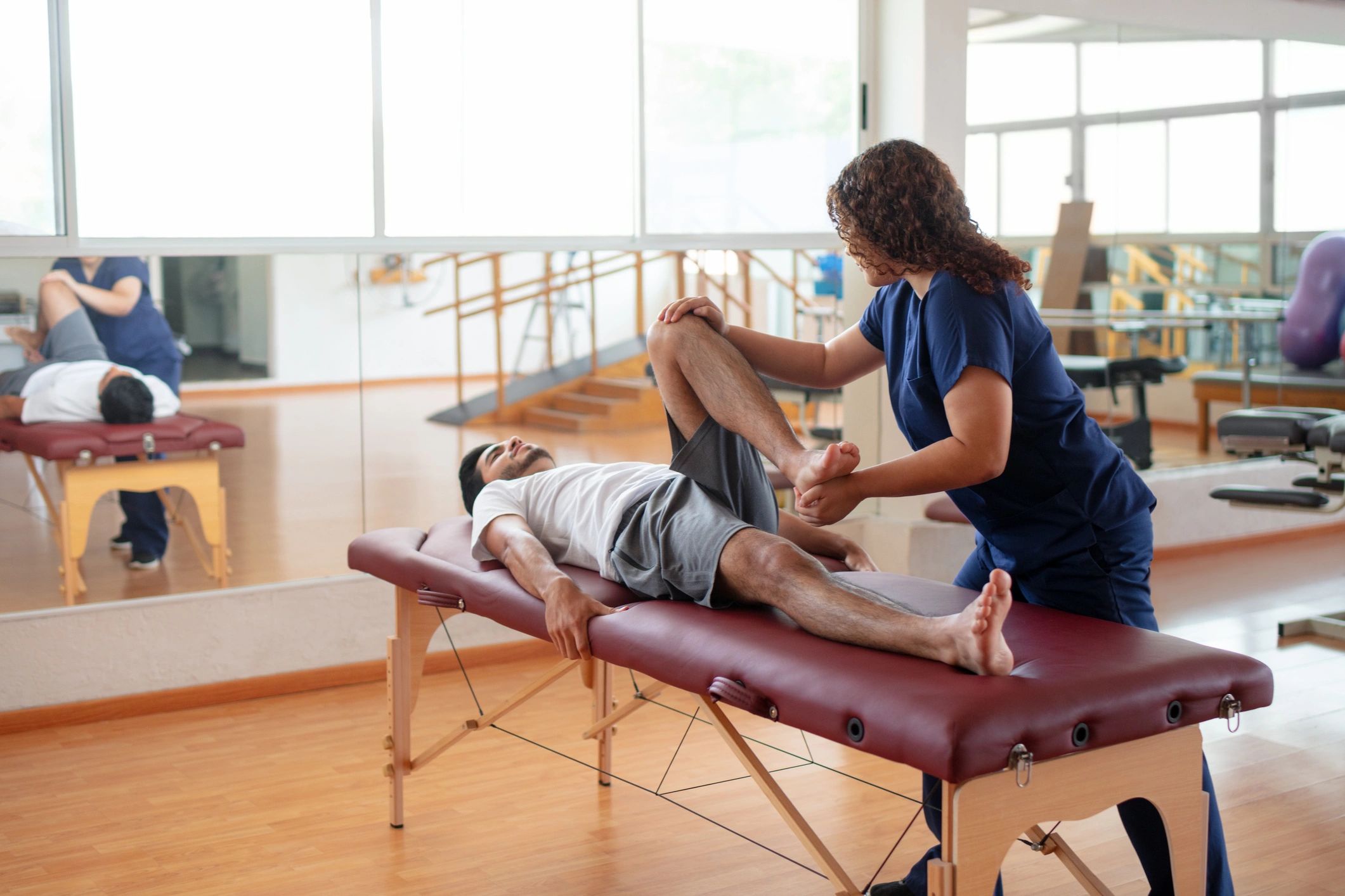 Sesión de terapia física con paciente en camilla